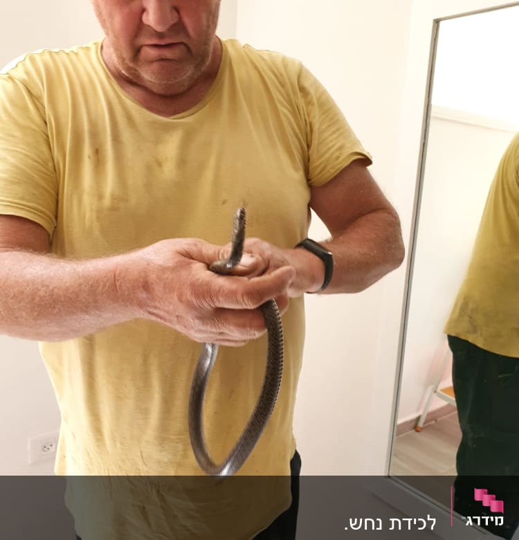 אדם מחזיק צינור מתכת גמיש בידיו